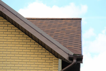 icon roof with new brown roofing tiles on residential property. banner on  roof for roofers....