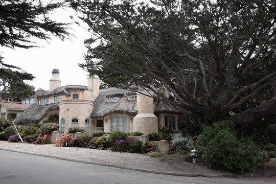 View of Typical fairytale cottage style Carmel house with  cypress tree on Carmel Beach in Carmel, California