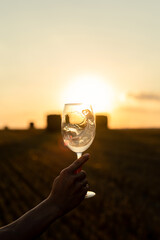 Glass of wine in hand at sunst