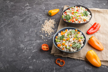 Pearl barley porridge with vegetables in blue ceramic bowls.  Side view, copy space