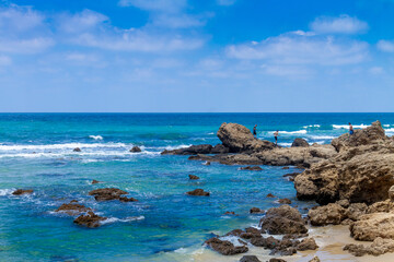 Fototapeta na wymiar A beautiful view of the rocks going into the sea on the Givat Olga beach. Israel.