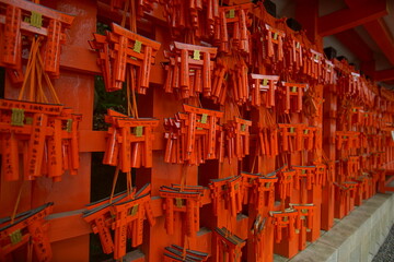 Red and black torii gates are lined up at shrine in Kyoto, Japan