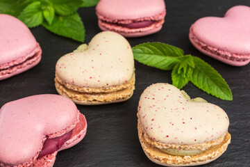 Obraz na płótnie Canvas heart shaped macaroons in pink and pale yellow with mint