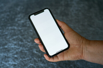 Woman hand holding the black smartphone with blank screen and modern frameless design Frau hält Smartphone in der Hand