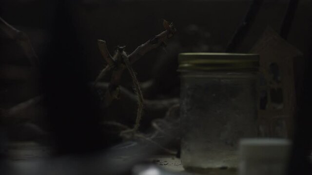 Close up of old jar and random objects on table in industrial warehouse