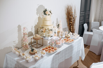 Candy bar at the banquet. Wedding table with sweets, cake, pastries, muffins, sugar treats. Event in the restaurant