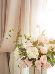 Pink Roses and flower arrangement bunch in luxury vase near window and pink curtains. Home decoration elegance style.