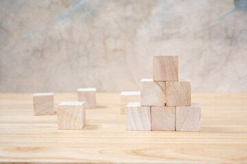 Wooden toy cubes on wooden table ang grey background