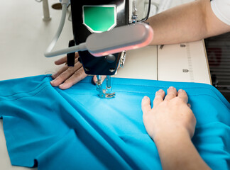 Obraz premium Designer tailor sew the dress. Woman use sewing machine for his work.