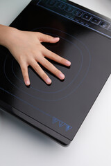 Hand on a non-hot induction cooker, modern technology and safety cooking surface, domestic...