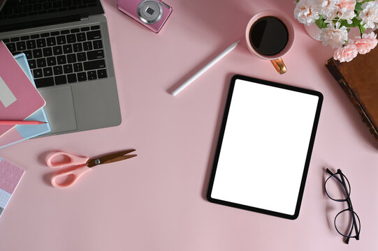 Mockup tablet with blank screen and laptop computer by various feminine equipment on female workspace.