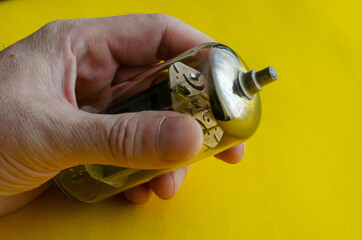 Male hand holds a vacuum tube on a yellow background.