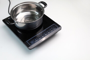 Modern stainless steel cooking pot on an induction stove.