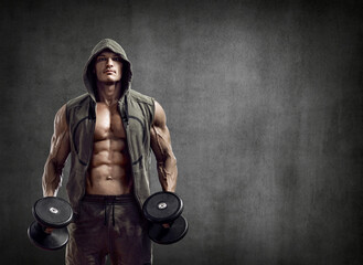 Fototapeta na wymiar portrait man - bodybuilder with dumbbells on grey background