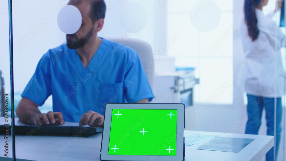 Aufkleber assistant giving doctor patient x-ray and tablet pc with green screen display. view of tablet comput