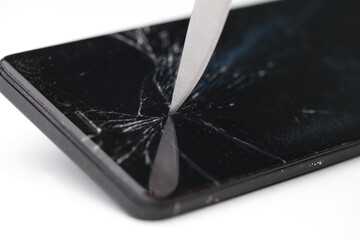 Cracked mobile smartphone smashed by a sharp knife