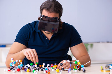Young male scientist sitting in the classroom