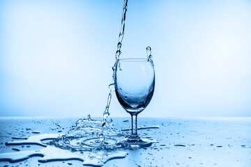 water splashing from glass isolated on blue background