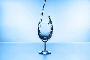 water splashing from glass isolated on blue background