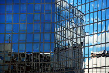 Fototapeta na wymiar A reflection of the sky on the wall of a glass building