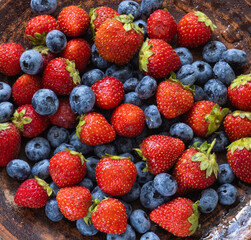 Strawberries and blueberries on a plate - summer fruits.