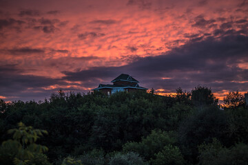 House on top of a mountain in a city at a bloody sunset