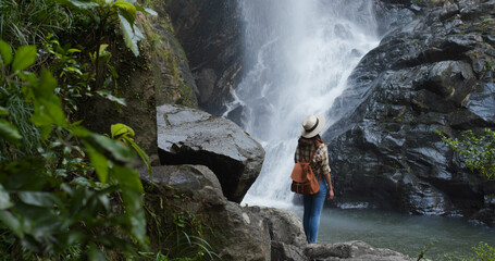 Woman enjoy the waterfall in forest