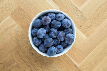 delicious fresh organic plums in a white bowl