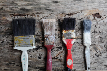 Old paint brush on old wood board.