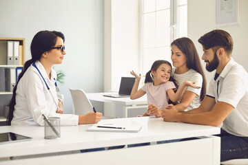 Fototapeta premium Happy family at a medical consultation with a doctor in a clinic.