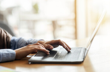 Female hands typing on laptop over blurred background