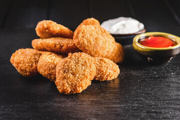 Chicken fried nuggets on a dark background. Fast food concept