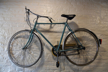 Naklejka na ściany i meble Blue vintage bicycle on a white brick wall background