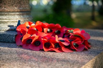 A red poppy wreath laid on a war memorial in remembrance of war dead