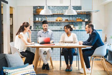 カジュアルな雰囲気のオフィス空間でミーティングするビジネスマンたち