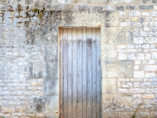 Fototapeta na wymiar View of an ancient wall and an old grungy door - large image in high resolution