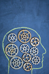 Silhouette of human head, chalk on the wall, gears in head, brainstorming, extraordinary thinking and intelligence.