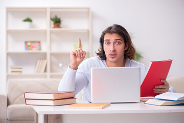 Young male student preparing for exams at home