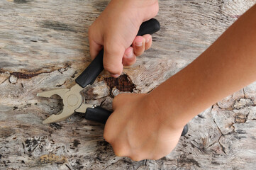 Carpentry hardware that has a black rubber coated handle. Isolated with wood grain backs.