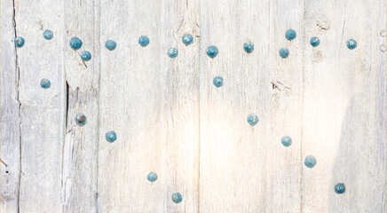White texture of the surface of an old wooden door with exposed blue nails - large image in high resolution