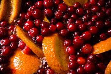metal pot on the stove. Oranges and cranberries in mulled wine