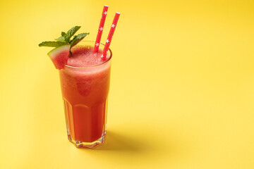 Watermelon cocktail with mint on yellow background with place for text