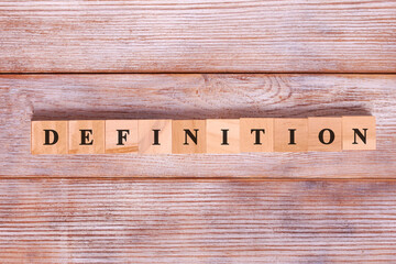 Word definition written on wood block on wooden background. Business concept.