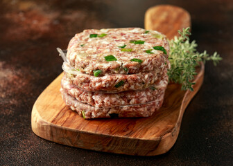 butcher made raw minced duck meat hamburger patties on wooden board ready to cook