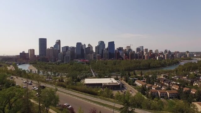 Drone Rises Up Above the Treeline to Reveal the City Skyline of Calgary, Alberta, Canada