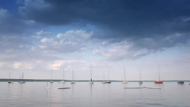 Total picture of lake, clouds on the sky, sailing boats on the water.