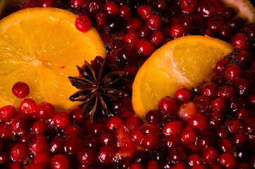 metal pot on the stove. Oranges and cranberries in mulled wine
