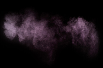 Purple powder explosion on black background. Colored powder cloud. Colorful dust explode. Paint...