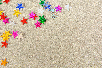 Background of multicolored stars on colored paper with sequins