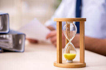 Young male employee in time management concept